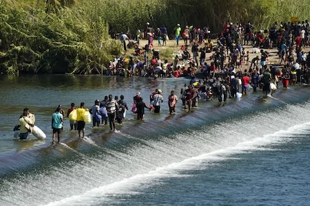 Haitian migrants use a dam to cross to and from the United States from Mexico, Friday, Sept. 17, 2021, in Del Rio, Texas. Thousands of Haitian migrants have assembled under and around a bridge in Del Rio presenting the Biden administration with a fresh and immediate challenge as it tries to manage large numbers of asylum-seekers who have been reaching U.S. soil. (AP Photo/Eric Gay)